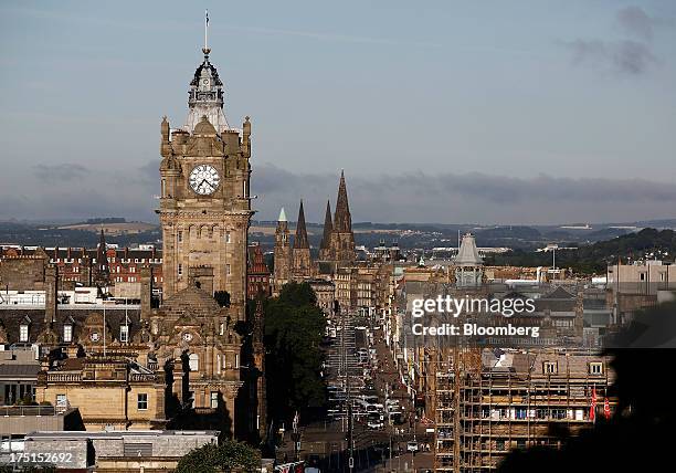 Vehicles pass along Princes Street as the clock tower of Balmoral hotel is seen on the city skyline in Edinburgh, U.K., on Wednesday, July 31, 2013....