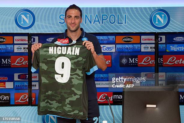 Napoli new forward Argentinian Gonzalo Higuain, former Real Madrid player, poses with an official football team jersey during his first press...