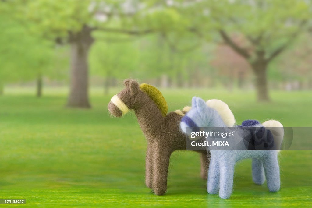 Two Felt Toy Horses on Printed Background Image