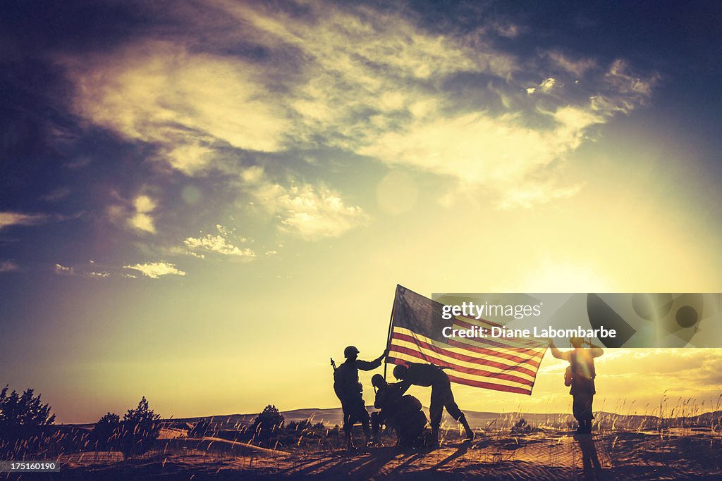 WWII Soldiers Raising The American Flag At Sunset