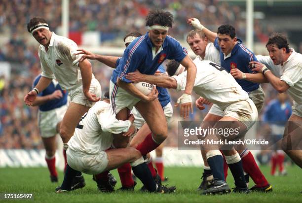 March 1991 - 5 Nations Rugby - England v France - Olivier Roumat is tackled by Brian Moore and Paul Ackford, watched by Wade Dooley , Dean Richards,...