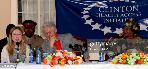 Former US President Bill Clinton's daughter Chelsea flanked by her father speaks during a joint press conference with Malawi's President Joyce Banda...