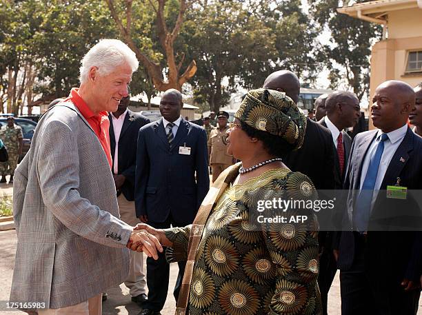 Former US President Bill Clinton is welcomed by Malawi's President Joyce Banda on August 1, 2013 at the Kamuzu Central Hospital Laboratory in...