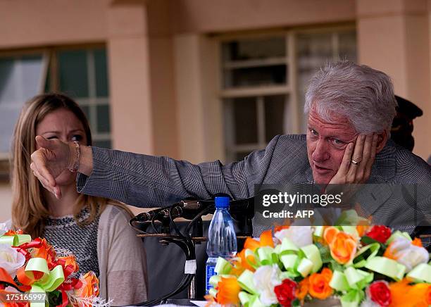 Former US President Bill Clinton flanked by his daughter Chelsea speaks during a joint press conference with Malawi's President Joyce Banda on August...