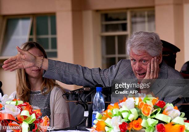 Former US President Bill Clinton flanked by his daughter Chelsea speaks during a joint press conference with Malawi's President Joyce Banda on August...