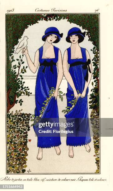 Young women in garden dresses of blue toile, black velvet belt, matching hat, with dove and flowers in a bower. Robe de jardin en toile bleu vif,...