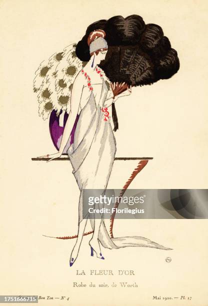 Woman in evening dress holding a huge fan. The gown in silver blue lame, shoulder straps of garlands of roses. Vase of chrysanthemums. The golden...