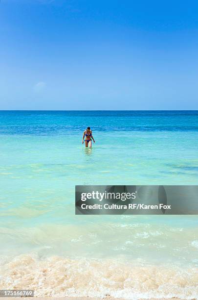 woman in sea at beach in front of dunn's river falls, jamaica - dunns river falls stock pictures, royalty-free photos & images