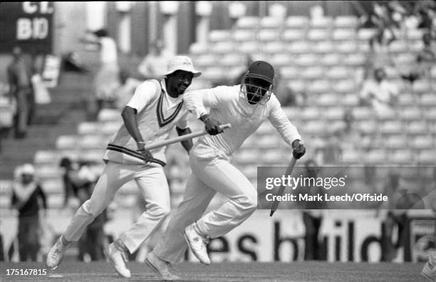 August 1984 The Oval - Cricket - 5th Test England v West Indies - Eldine Baptiste smiles as Desmond Haynes runs from the pitch with a stump in each...