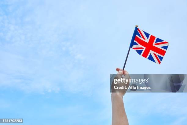 hand holding flag against blue sky - only japanese stock pictures, royalty-free photos & images