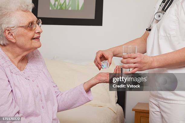 nurse giving pills to senior patient, close-up - drug bust stock pictures, royalty-free photos & images