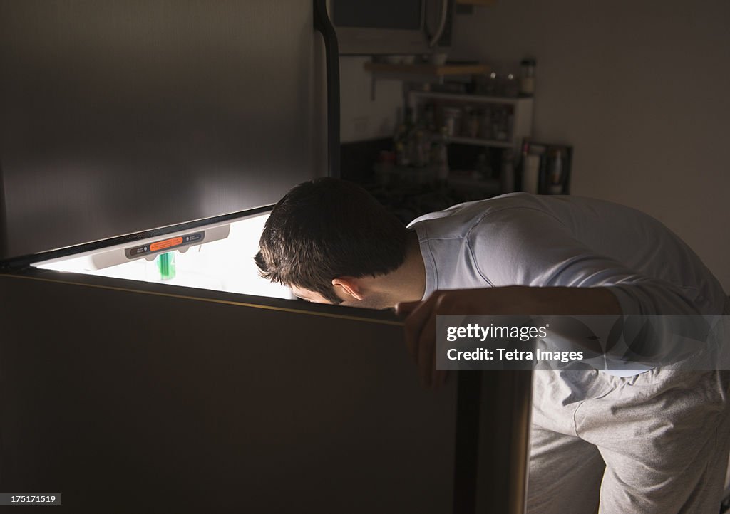 USA, New Jersey, Jersey City, Man opening fridge at night