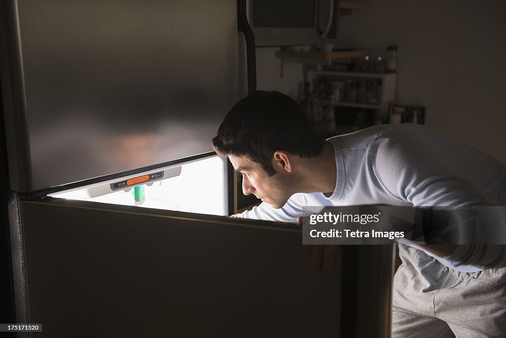 USA, New Jersey, Jersey City, Man opening fridge at night