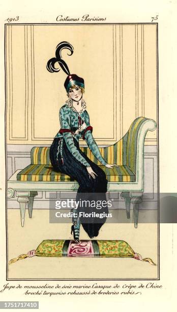 Woman in skirt of marine blue chiffon, vest of turquoise crepe de chine, seated on a chaise longue. Jupe de mousseline de soie marine, casaque de...