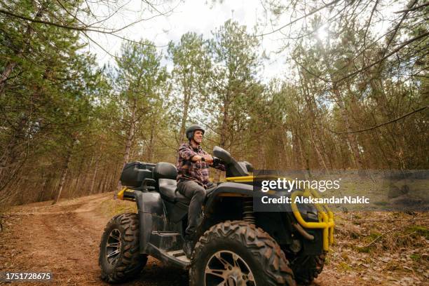 hombre mayor montando un quad - vehículo de todo terreno fotografías e imágenes de stock