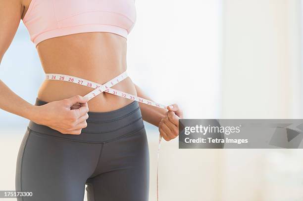 usa, new jersey, jersey city, woman measuring waist - abnehmen stock-fotos und bilder