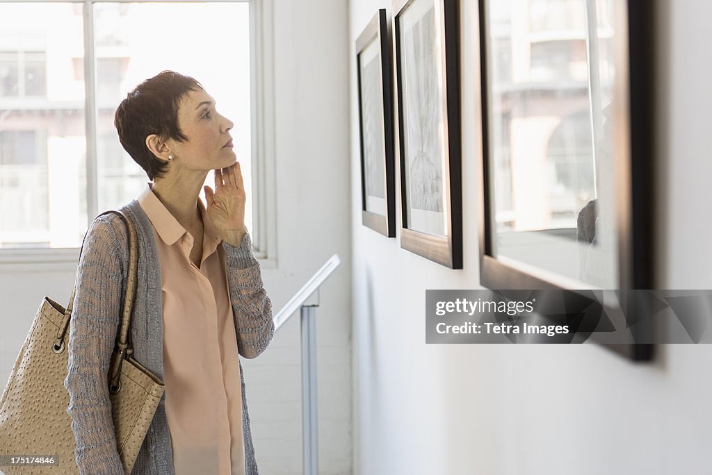 USA, New Jersey, Jersey City, Woman watching photographs in art gallery