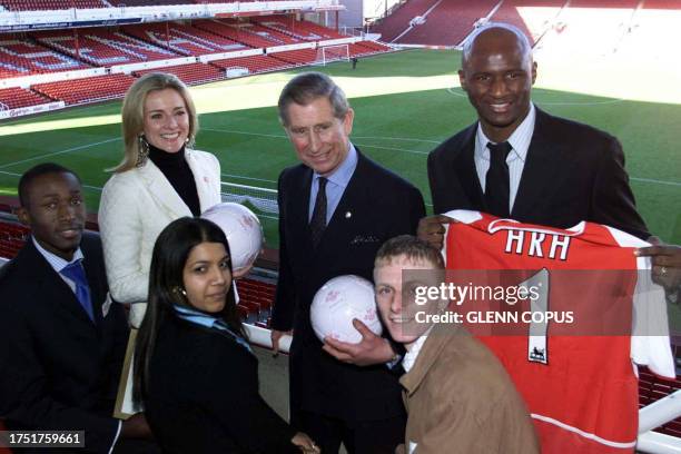 The Prince of Wales is presented with an Arsenal shirt by club captain Patrick Vieira as he visits Arsenal FC's Highbury stadium in north London,...