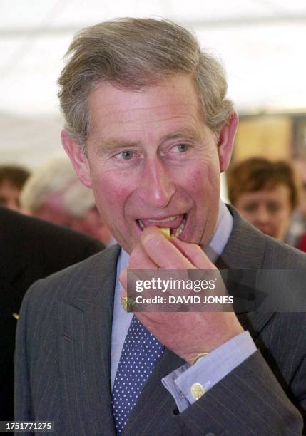 The Prince of Wales samples the fare during a visit to the British cheese festival at Stow-on-the-Wold 28 September 2001. The Prince was a first-time...