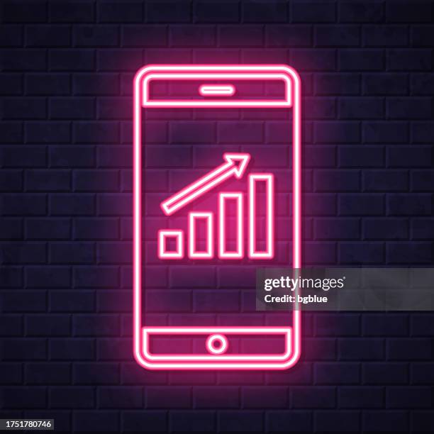 illustrazioni stock, clip art, cartoni animati e icone di tendenza di grafico di crescita su smartphone. icona al neon incandescente su sfondo muro di mattoni - ora del giorno