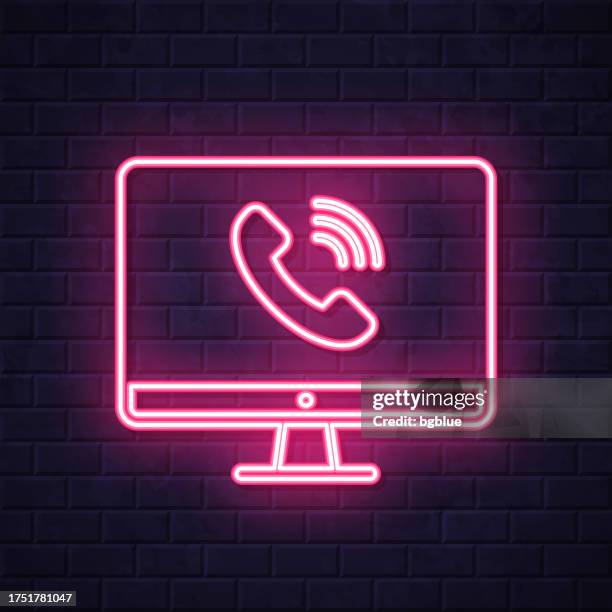 desktop computer with incoming call. glowing neon icon on brick wall background - flat screen on wall stock illustrations