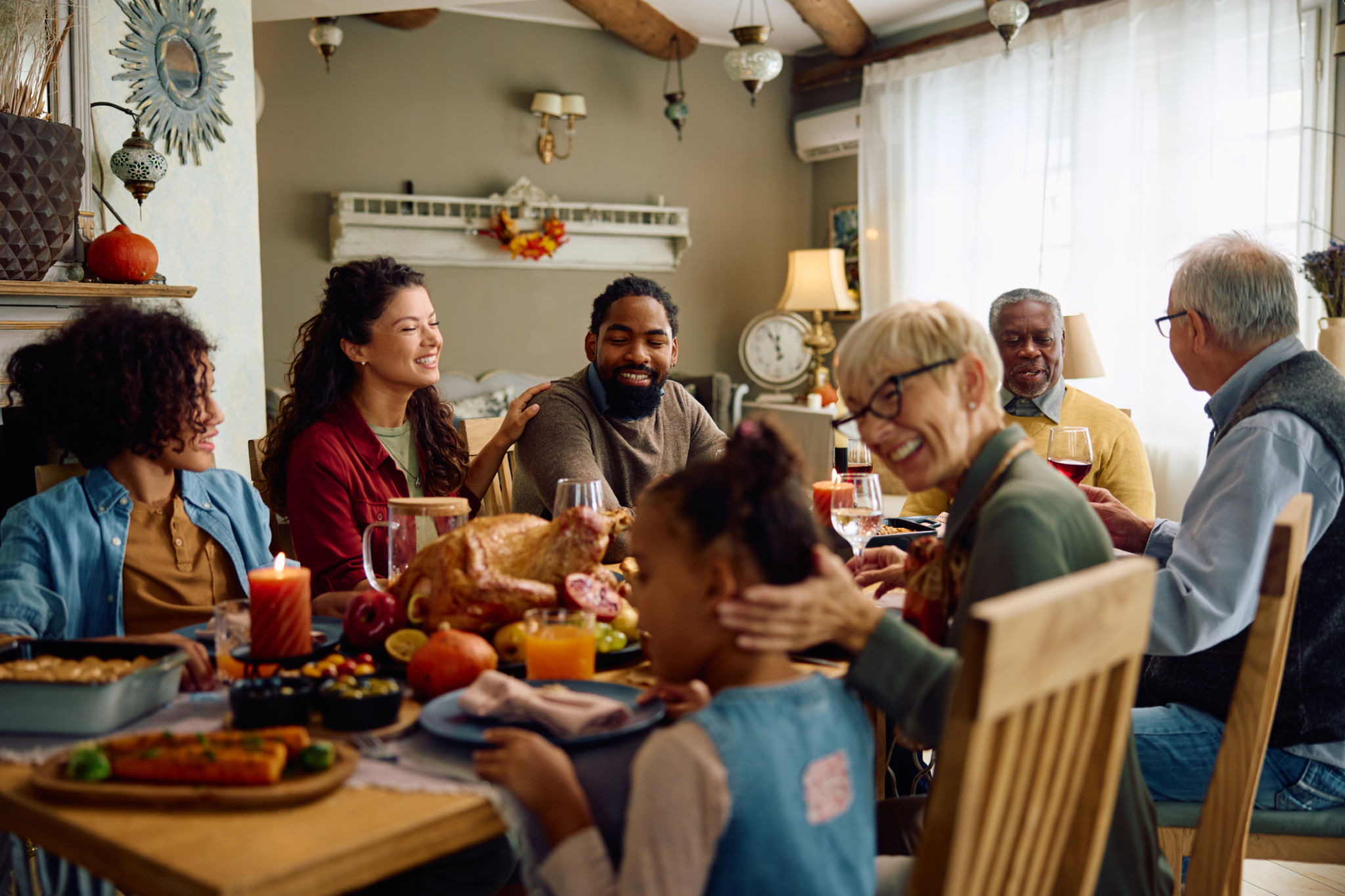 Happy multiracial extended family celebrating Thanksgiving at dining table. Happy multiracial extended family celebrating Thanksgiving at dining table.