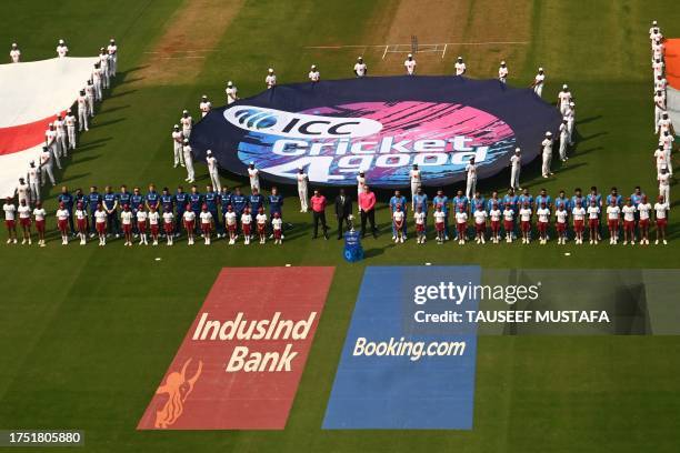 England's and India's players stand during their national anthems before the start of the 2023 ICC Men's Cricket World Cup one-day international...