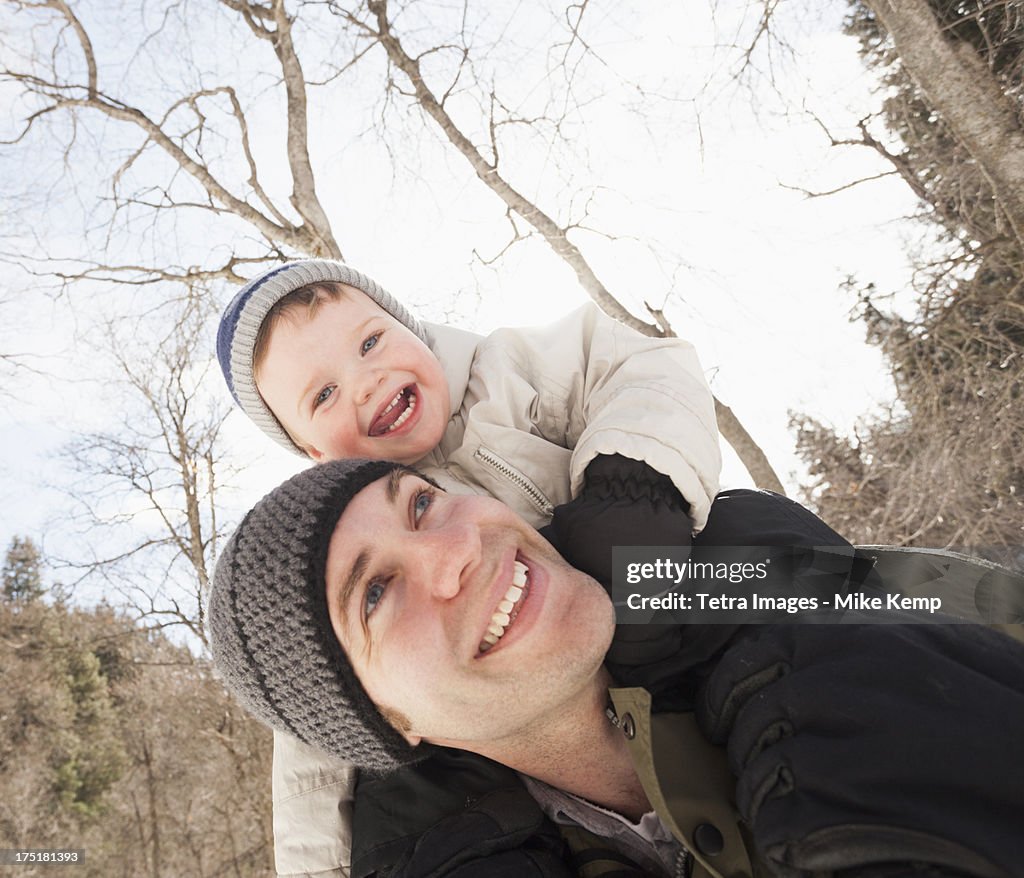 USA, Utah, Highland, Young man carrying his son (12-17 months) on shoulders
