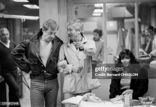 Jean-Paul Belmondo, Carlos Sotto Mayor et le maquilleur Charly Koubesserian sur le tournage du film 'Le Marginal' à Paris en avril 1983