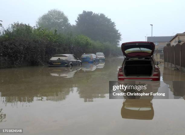 In this aerial view, water damaged cars are seen as flood waters begin to recede in the village of Catcliffe after Storm Babet flooded homes,...