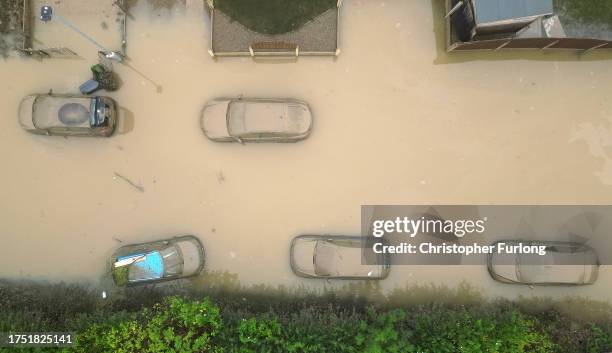 In this aerial view, water damaged cars are seen as flood waters begin to recede in the village of Catcliffe after Storm Babet flooded homes,...