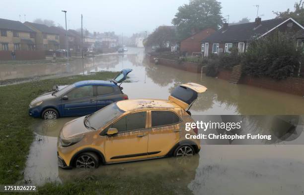 In this aerial view, water damaged cars are seen as flood waters begin to recede in the village of Catcliffe after Storm Babet flooded homes,...