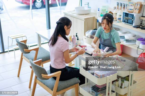 young female business owner assisting customer in nail salon - nail salon stock pictures, royalty-free photos & images
