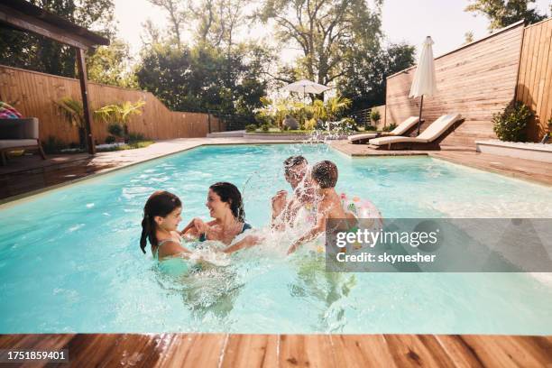 cheerful family having fun during summer day in the pool. - boy-with-a-girl-playing-at-the-poolside stock pictures, royalty-free photos & images