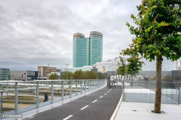 rabobank multinational bank headquarters in utrecht, netherlands seen from the bridge over the train tracks - utrecht stock pictures, royalty-free photos & images