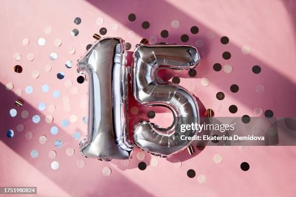 silver numbers 15 fifteen years balloons in sunlight pink background - celebrating 15 years stock pictures, royalty-free photos & images