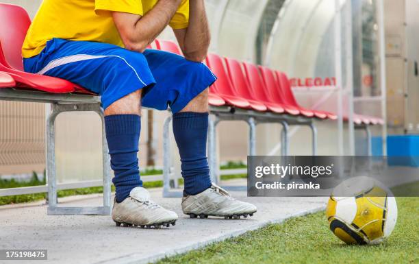 jugador de fútbol sentado en el banco - subs bench fotografías e imágenes de stock