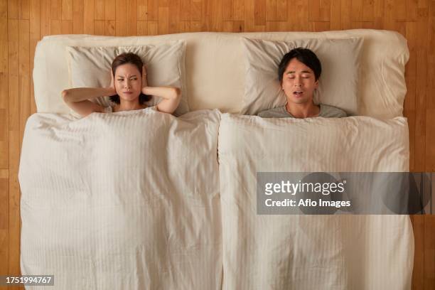 japanese couple in bed - schnarchen mann stock-fotos und bilder