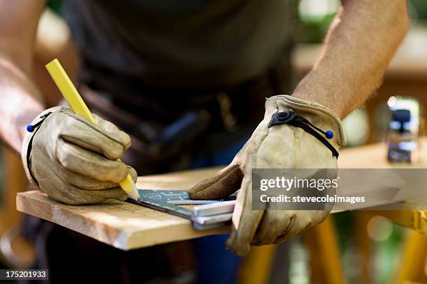 carpenter medir un tablón de madera. - guantes-de-trabajo fotografías e imágenes de stock