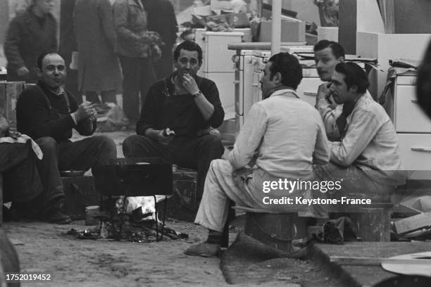 Ouvriers en pause déjeuner lors des préparatifs du salon des arts ménagers au Grand Palais à Paris, le 23 février 1955.