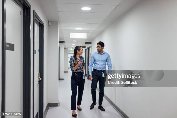 doctors discussing on the move - doctor on the move stock pictures, royalty-free photos & images