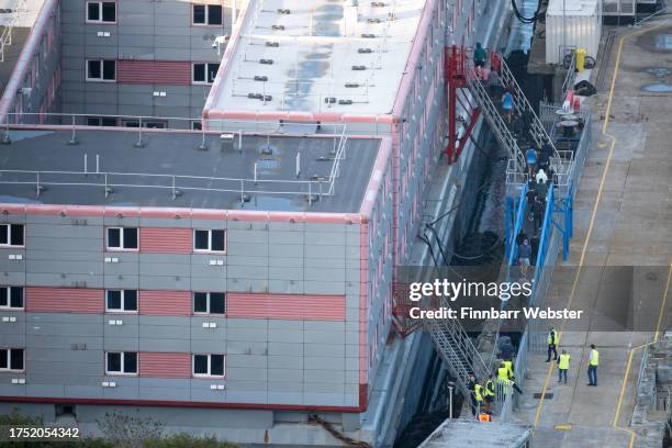 Asylum seekers and staff return to the Bibby Stockholm after an evacuation following an alarm sounding at Portland Port, on October 22, 2023 in...