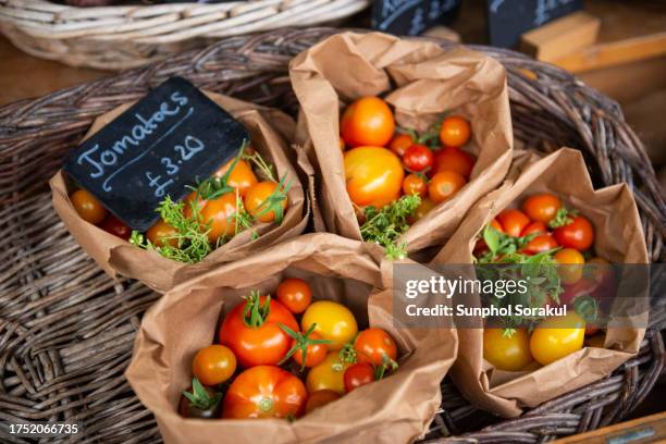 organic vegetables displayed in paper bags on a market stall, london uk - market stock pictures, royalty-free photos & images