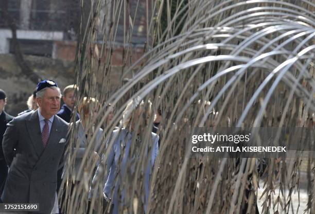 Britain's Prince Charles reads the names of the Holocaust victims on leaves of the tree-ssculpture of the Holocaust memorial place at the synagogue...