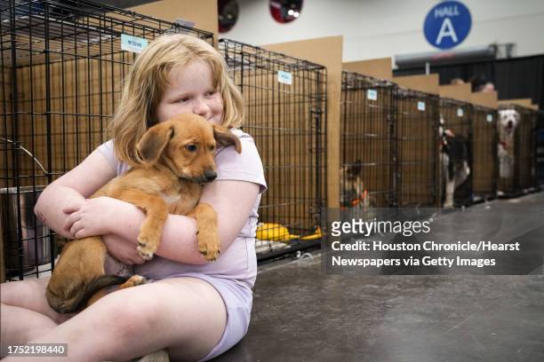Cody Passwaters hugs her new puppy as her dad fills out adoption paperwork during Petco Love's Mega Adoption Event on Saturday, Oct. 21 at the George...