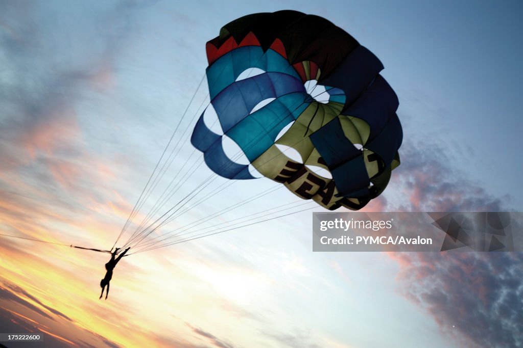 A person paragliding whilst upside down at sunset, Cafe del Mar, Ibiza