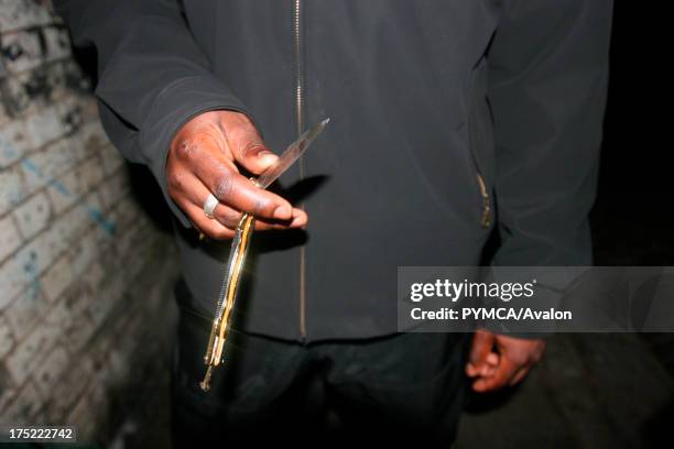 Close-up of a youth holding a 'butterfly' knife, London, UK 2006.