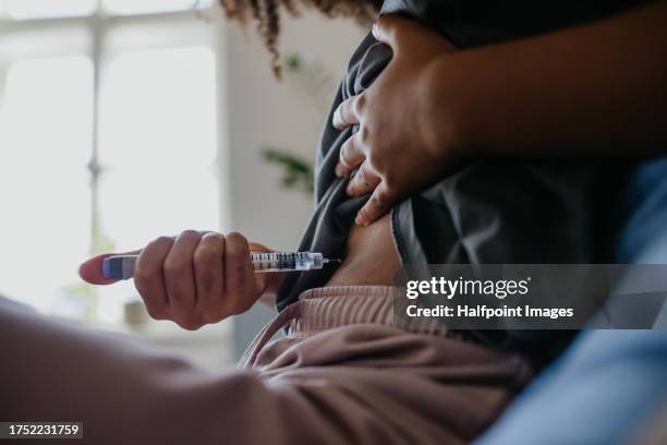 close up of teenage girl injecting insulin in her abdomen in the morning, feeling her blood sugar is high. - injecting stock pictures, royalty-free photos & images