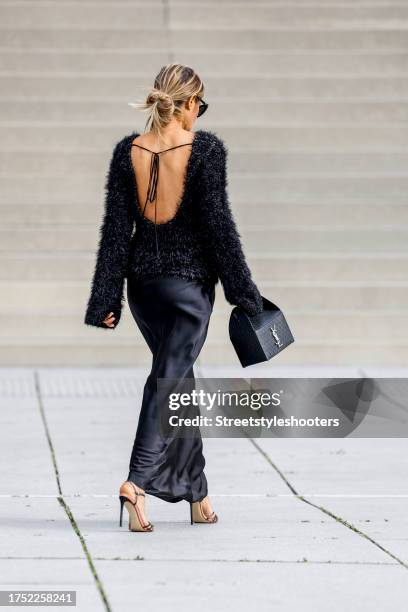 Influencer Gitta Banko, wearing a black backfree pullover by Victoria Beckham, a black long skirt by Frame, sandals by Francesco Russo, a black bag...