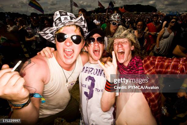 Three boys posing for camera in crowd, Download Festival UK.